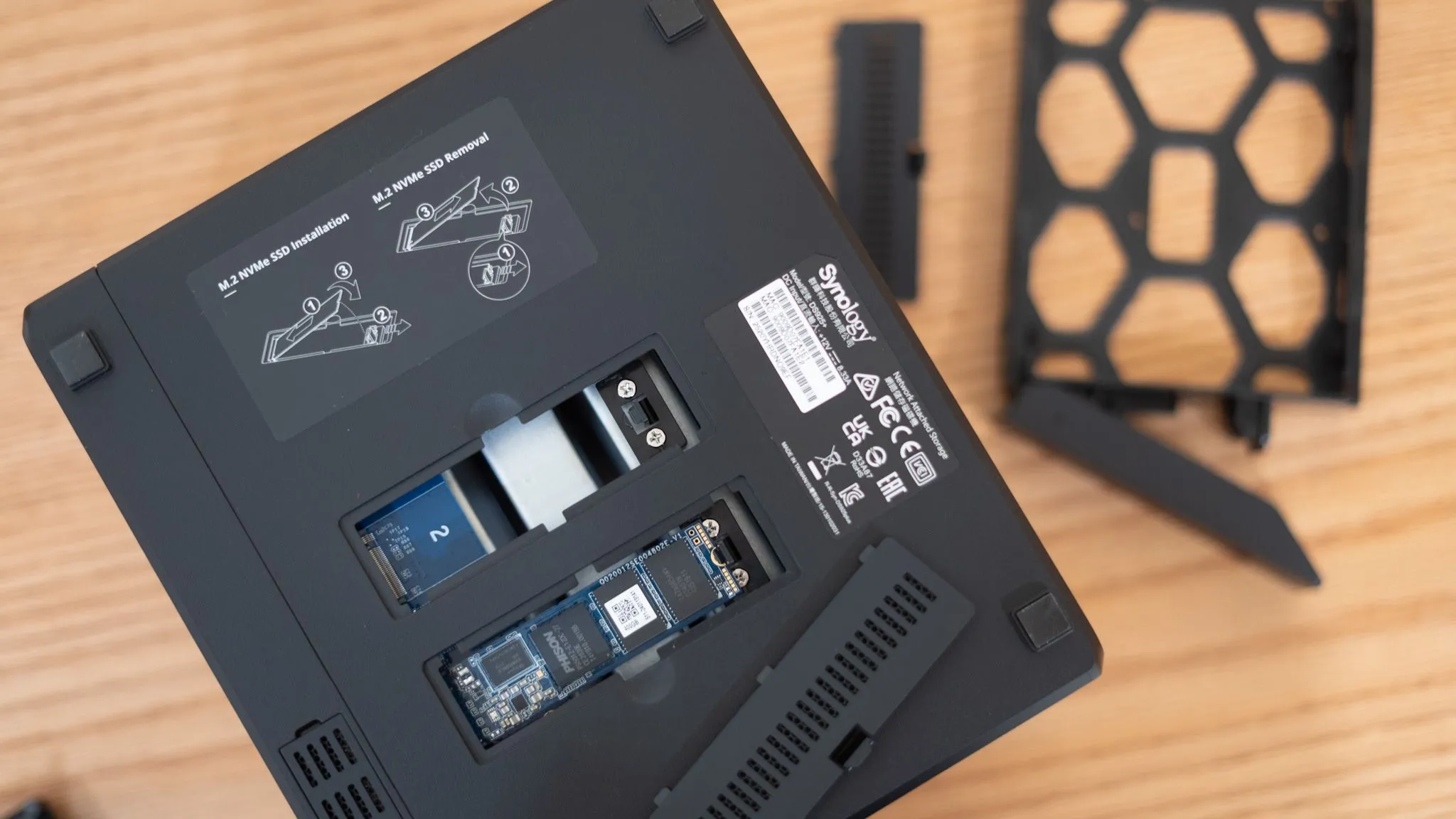 Các khe cắm NVMe và khay ổ cứng trên thiết bị NAS Synology, thể hiện khả năng quản lý và mở rộng linh hoạt của hệ thống lưu trữ