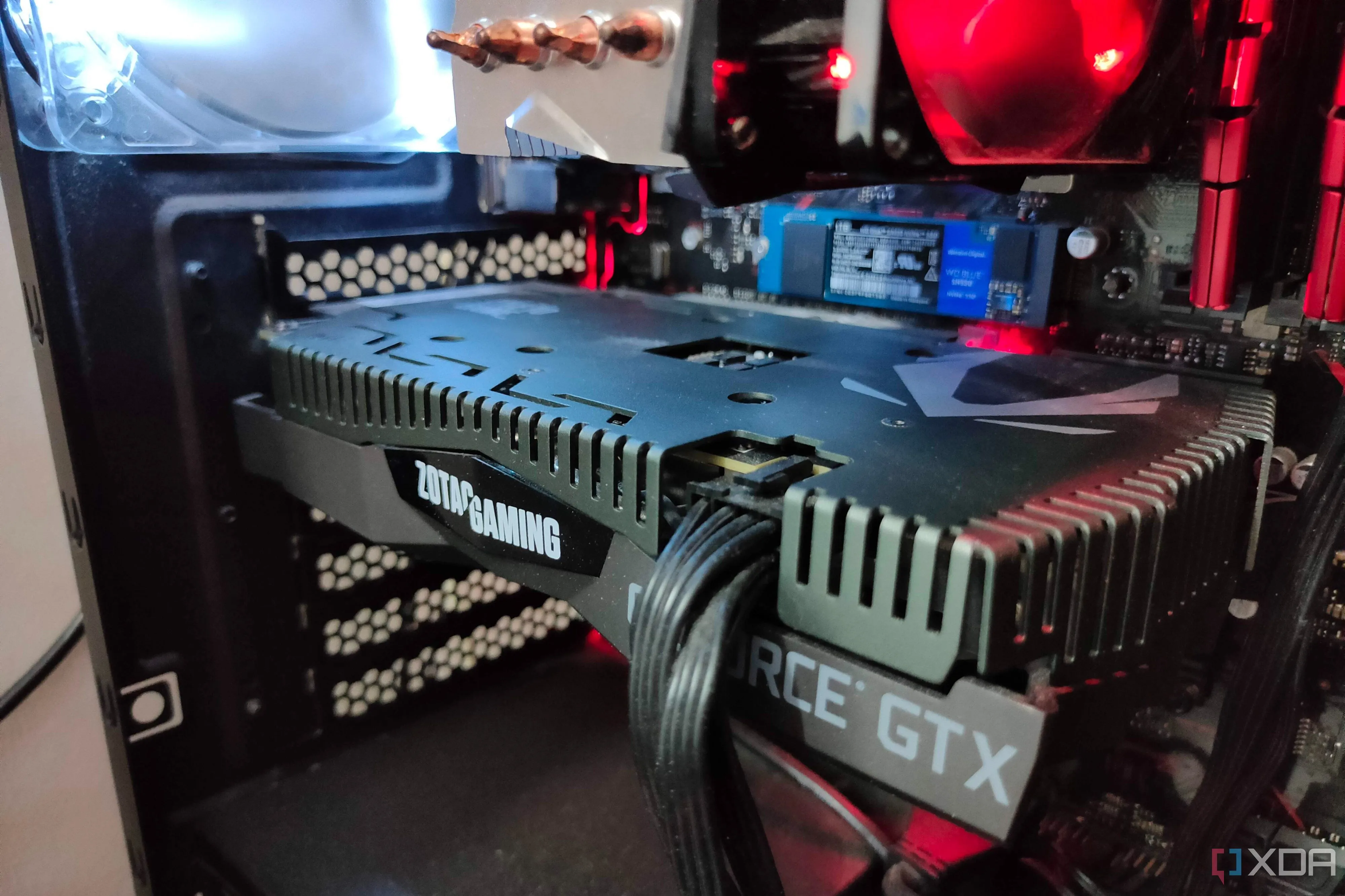 Hình ảnh cận cảnh card đồ họa NVIDIA GTX 1660 Ti bên trong một bộ PC gaming với dây cáp nguồn được cắm