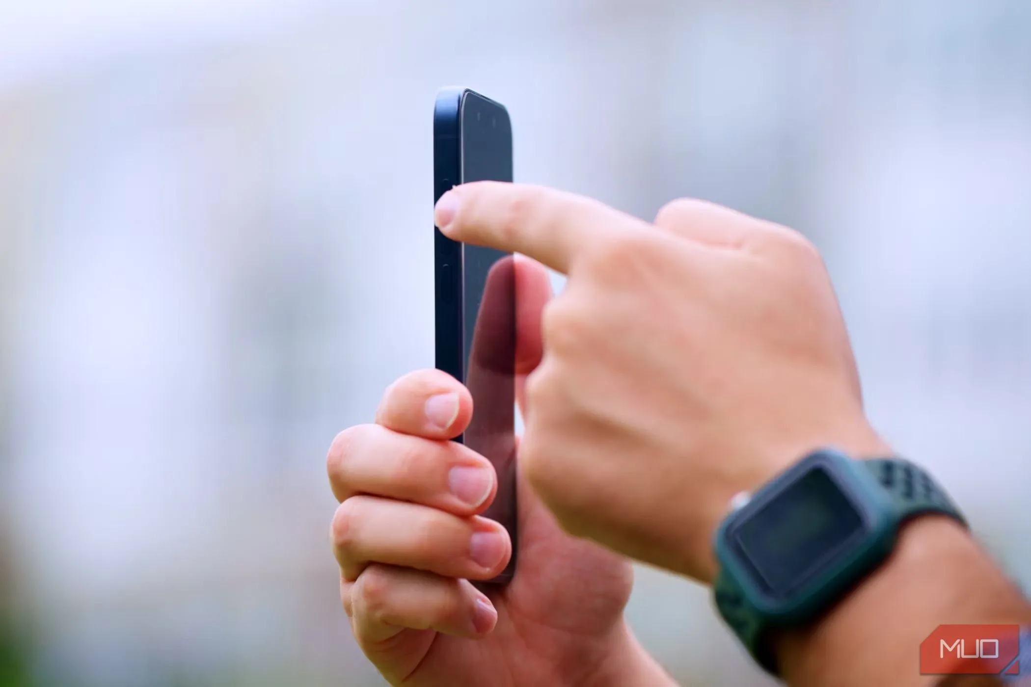 Người đàn ông đang tương tác với nút tác vụ trên iPhone 15 Pro, thể hiện tính năng cao cấp nhưng có thể ít dùng hàng ngày