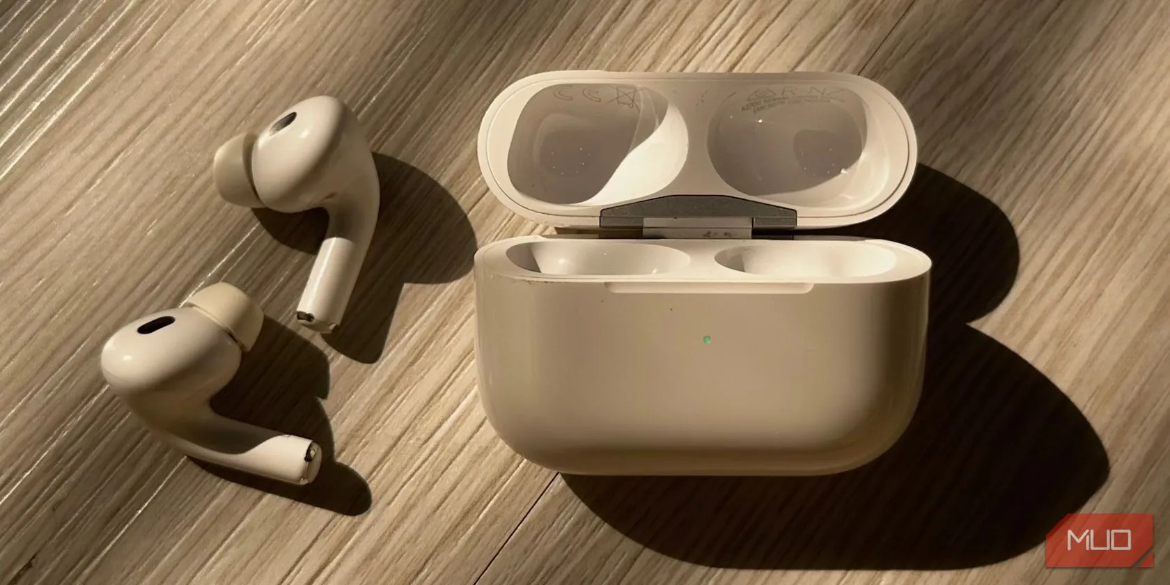 AirPods đang sạc với đèn báo trạng thái màu xanh lá sáng lên