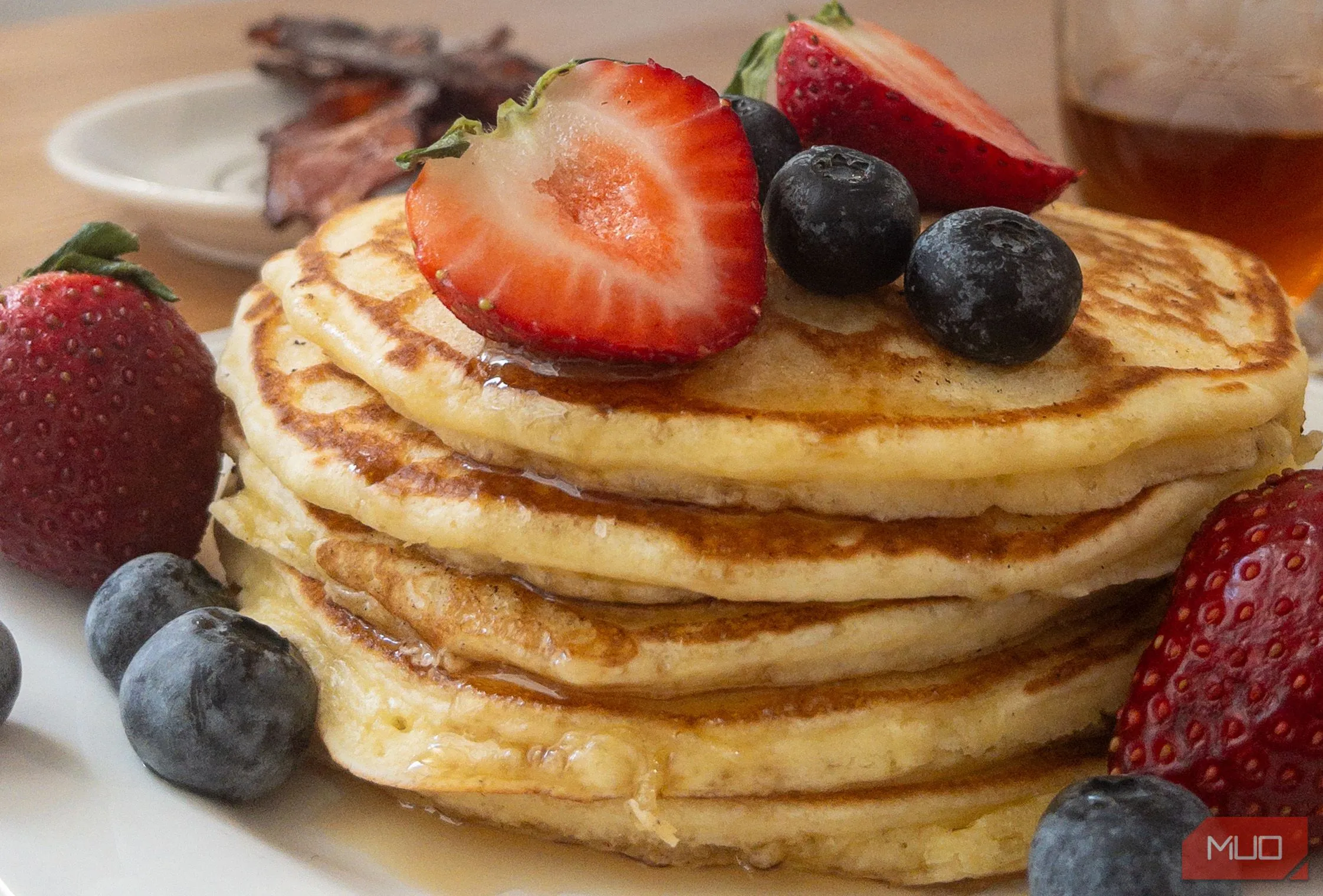 Ảnh chụp một chồng bánh pancake từ góc ngang tầm mắt, làm nổi bật kết cấu và độ cao
