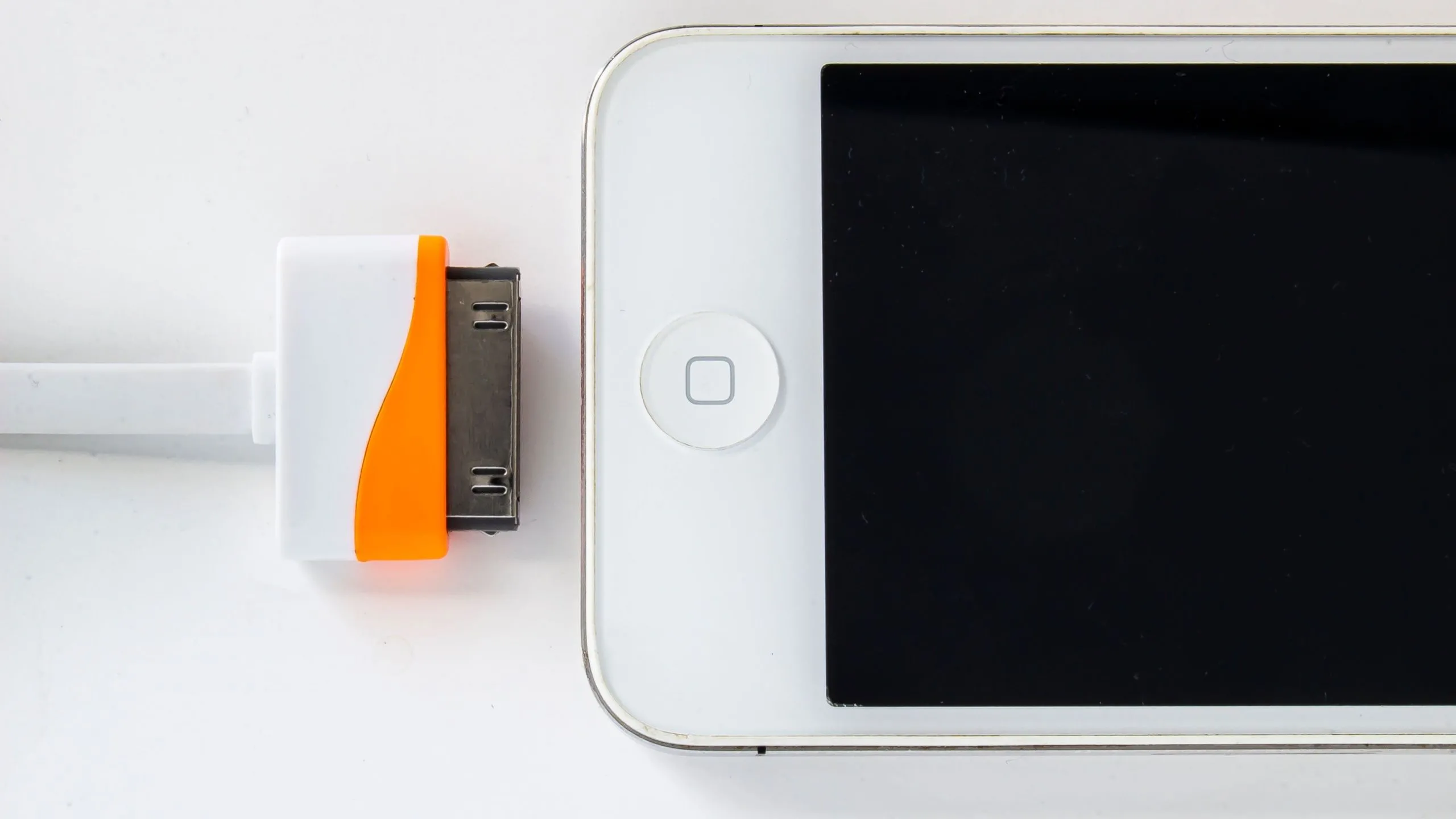 Điện thoại iPhone đời đầu với cáp sạc 30 chân, biểu tượng của kỷ nguyên iPhone những năm 2007-2012.