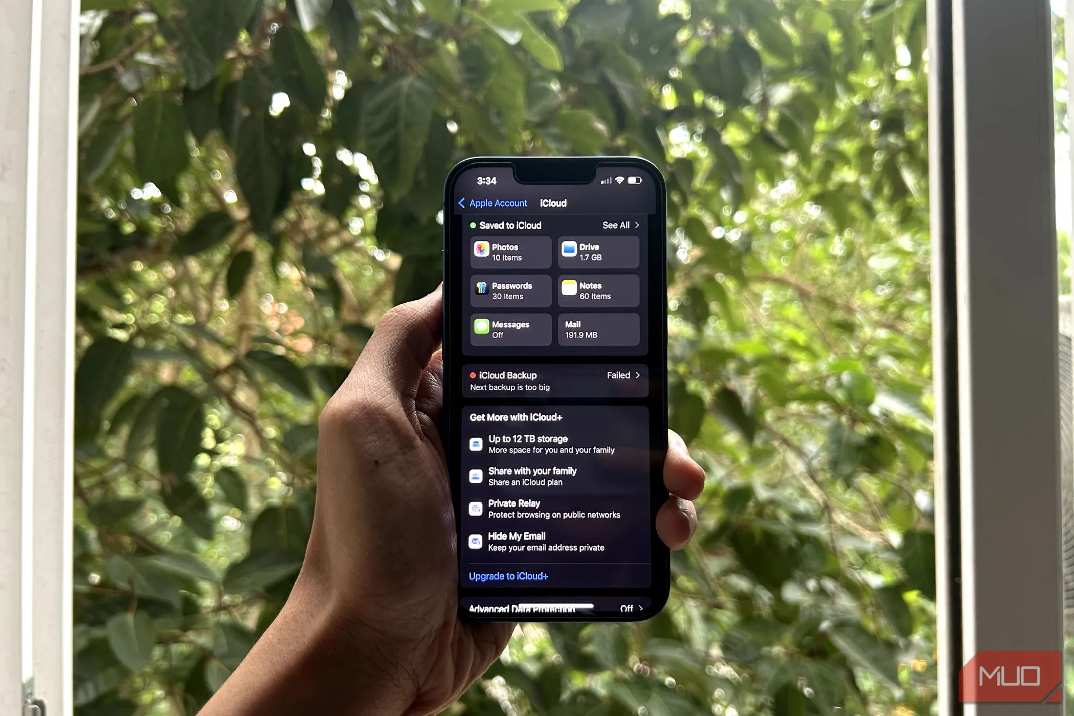 Điện thoại iPhone trên tay người dùng hiển thị menu cài đặt iCloud, minh họa dung lượng lưu trữ giới hạn