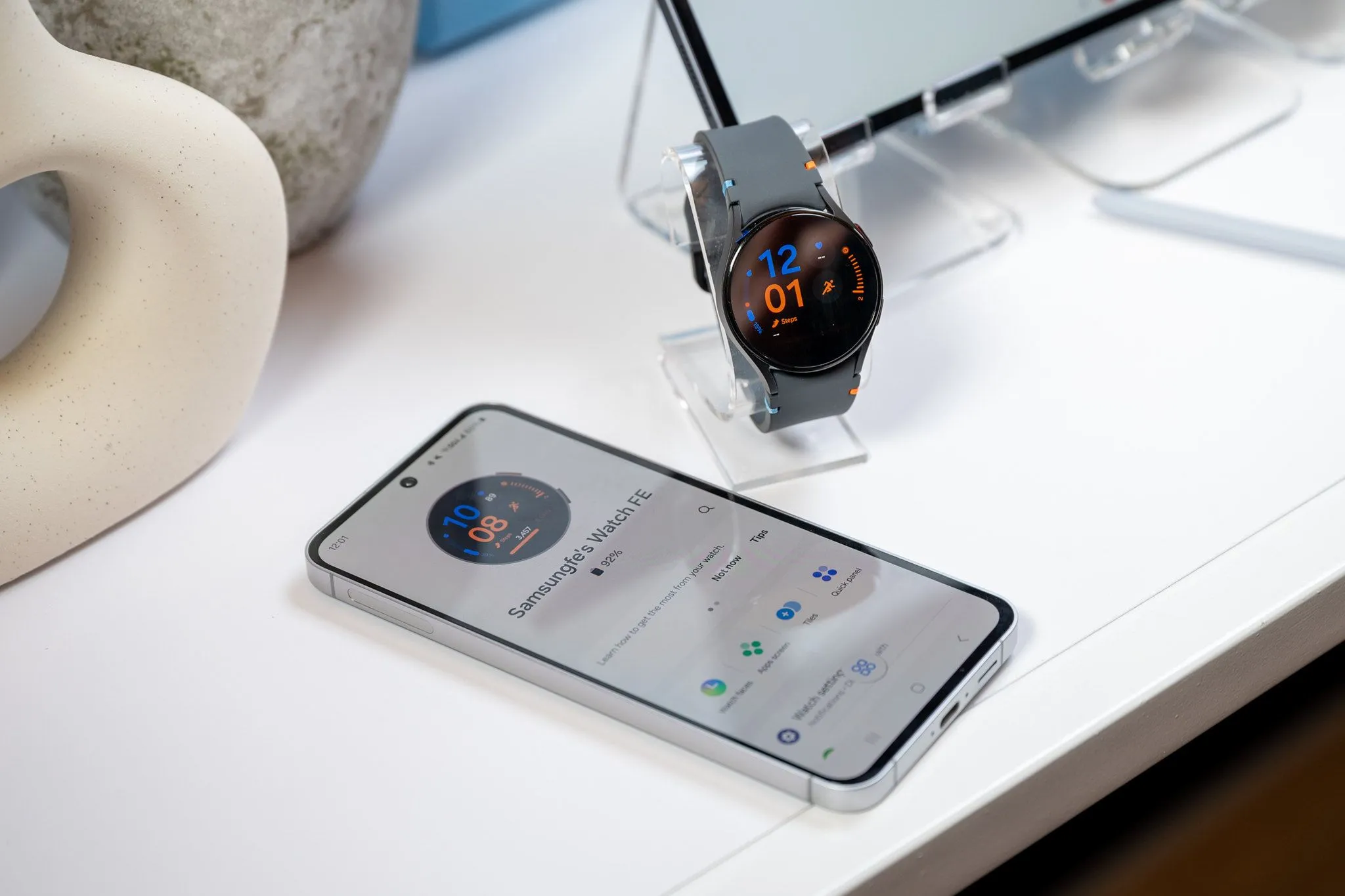 Điện thoại Samsung Galaxy S24 FE đang sạc pin cho đồng hồ thông minh Galaxy Watch LTE qua cáp USB-C, minh họa tính năng sạc ngược.