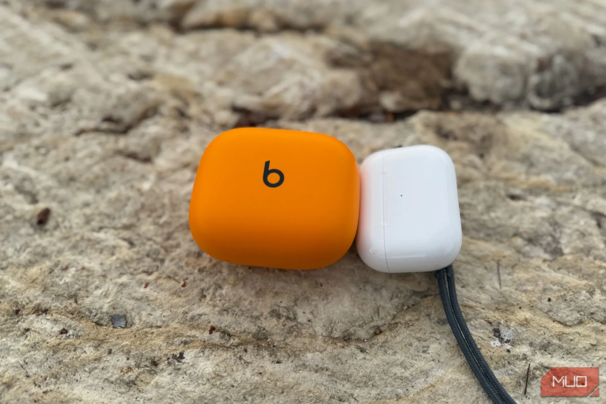 Hộp sạc cồng kềnh của Powerbeats Pro 2 đặt cạnh hộp sạc nhỏ gọn của AirPods Pro 2
