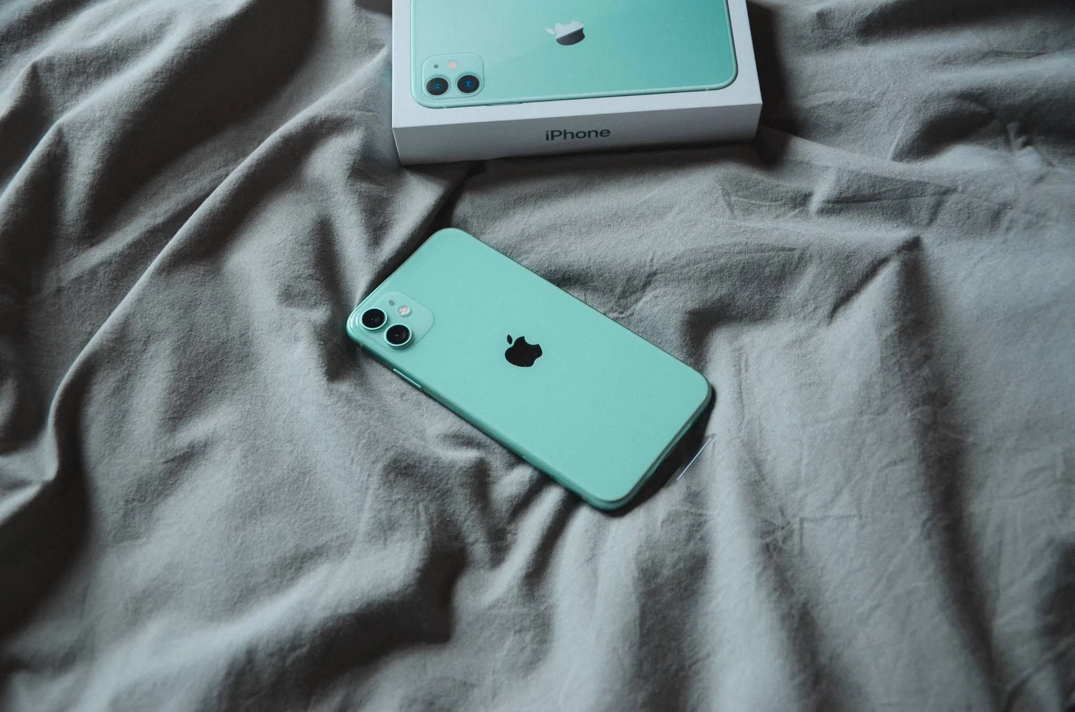 iPhone đặt trên chăn hoặc ga trải giường khi đang sạc