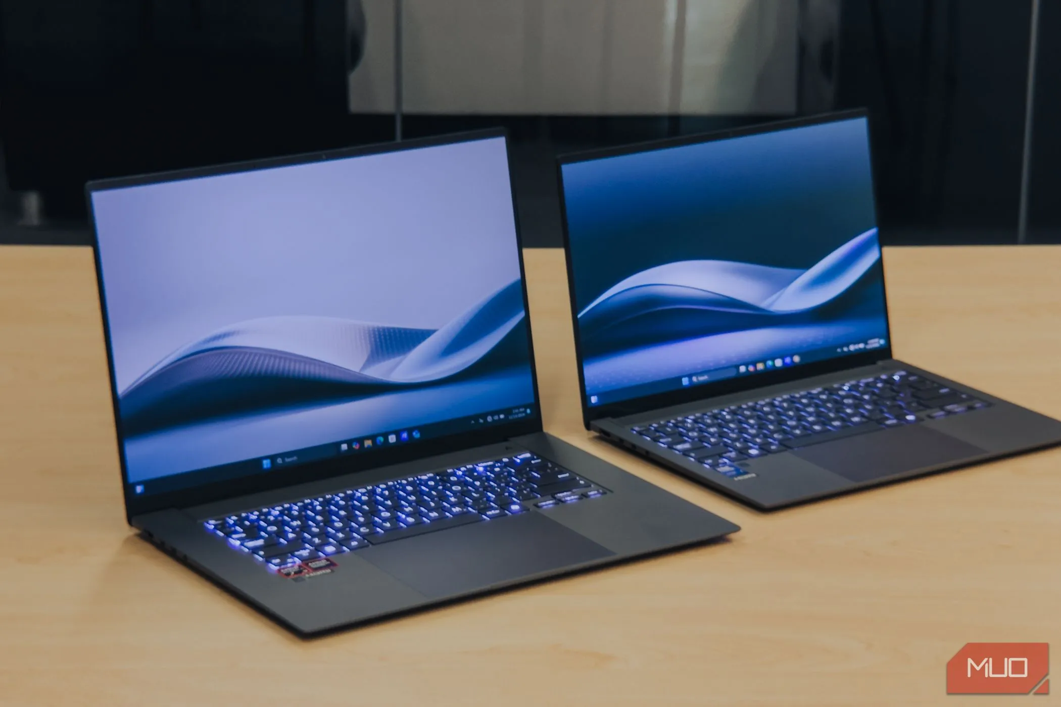 Kích thước của ASUS Zenbook S 16 OLED đặt cạnh Zenbook S 14 trên bàn gỗ