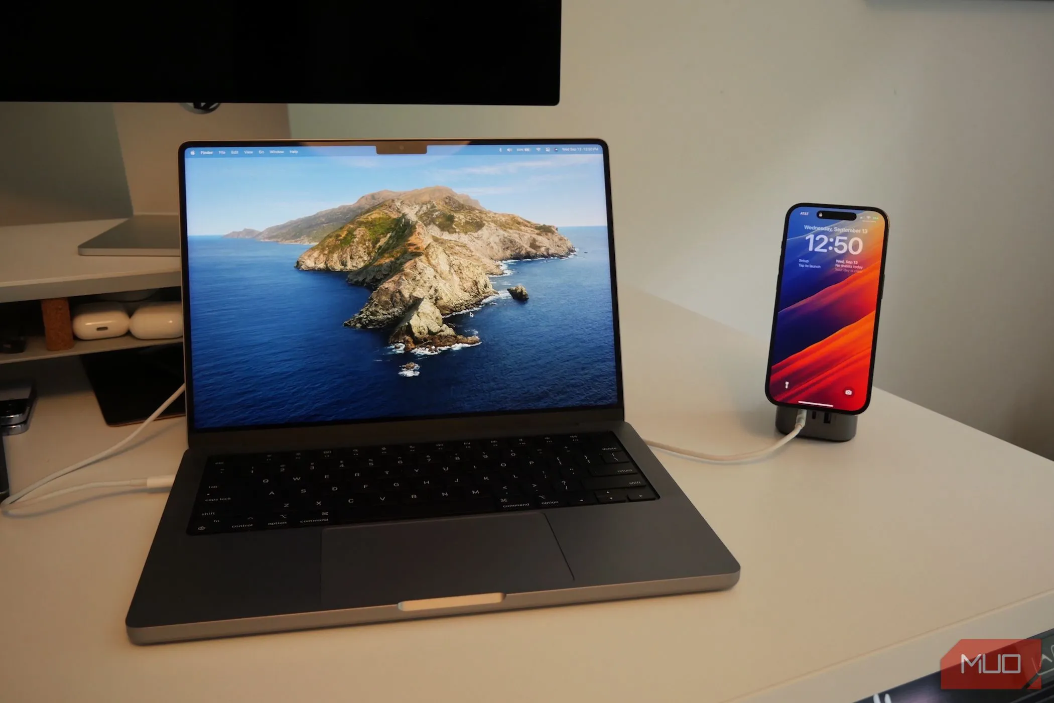 MacBook Pro và iPhone đang sạc, minh họa khả năng iPhone làm loa ngoài cho Mac