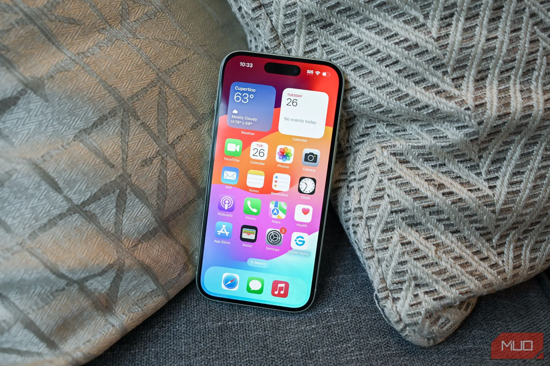 Màn hình chính trên iPhone 15 hiển thị giao diện iOS 26 mới mẻ, minh họa cho việc hỗ trợ hệ điều hành