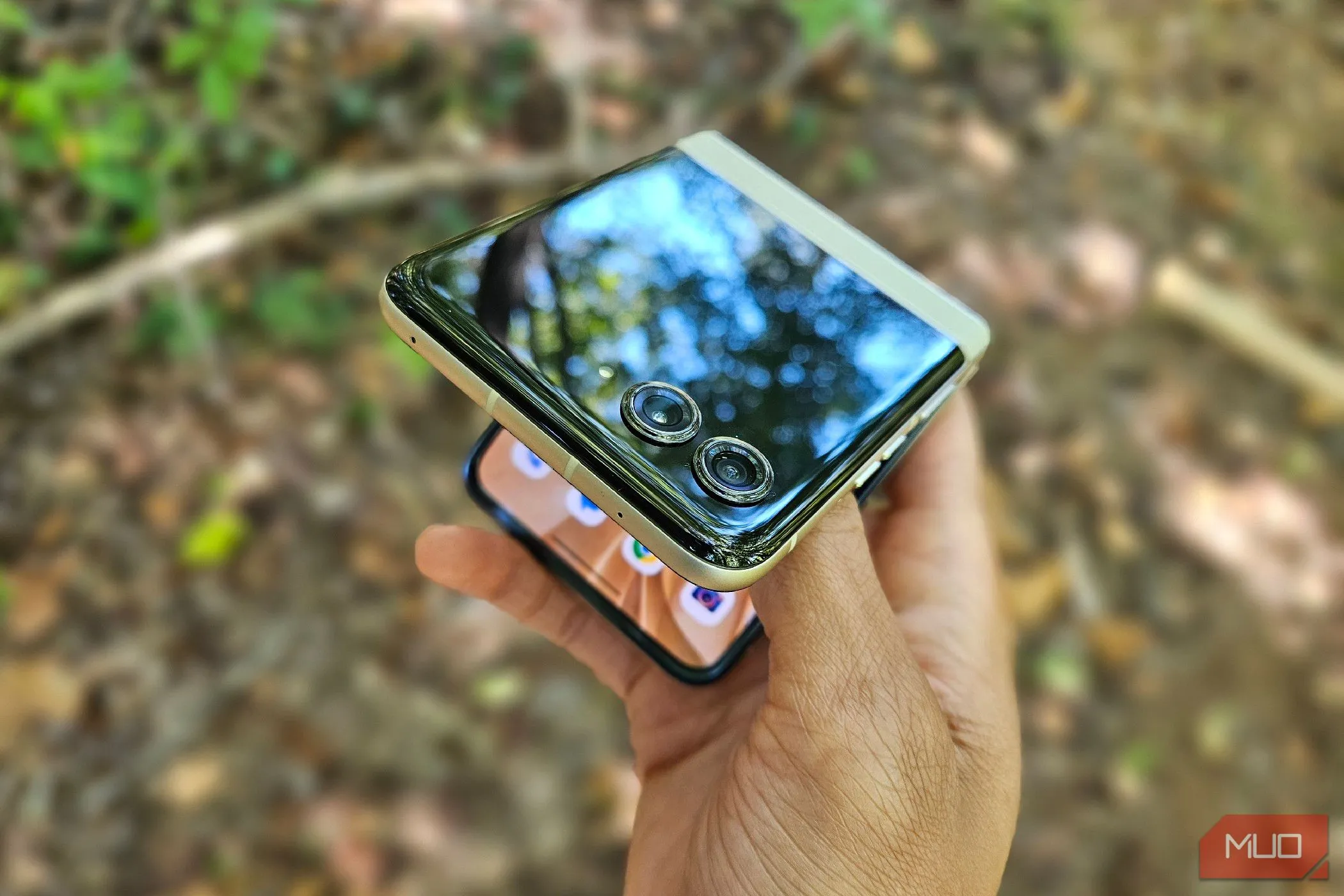 Một bàn tay đang cố mở điện thoại Motorola Razr 2024 dạng vỏ sò, thể hiện sự tiện lợi của thiết kế gập