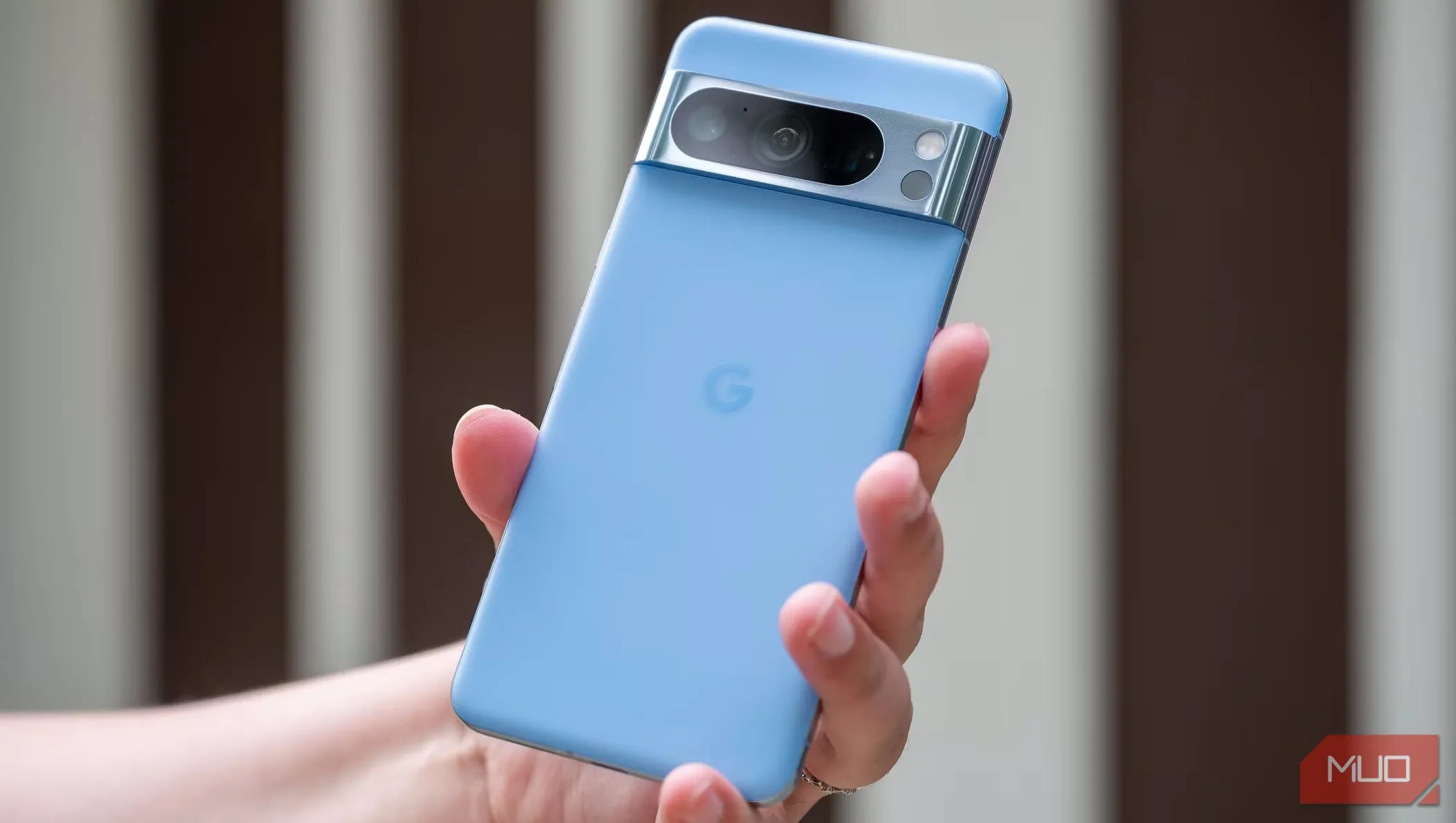 Một người đàn ông cầm điện thoại Google Pixel 8 Pro màu xanh, minh họa việc lựa chọn thời điểm bán điện thoại cũ
