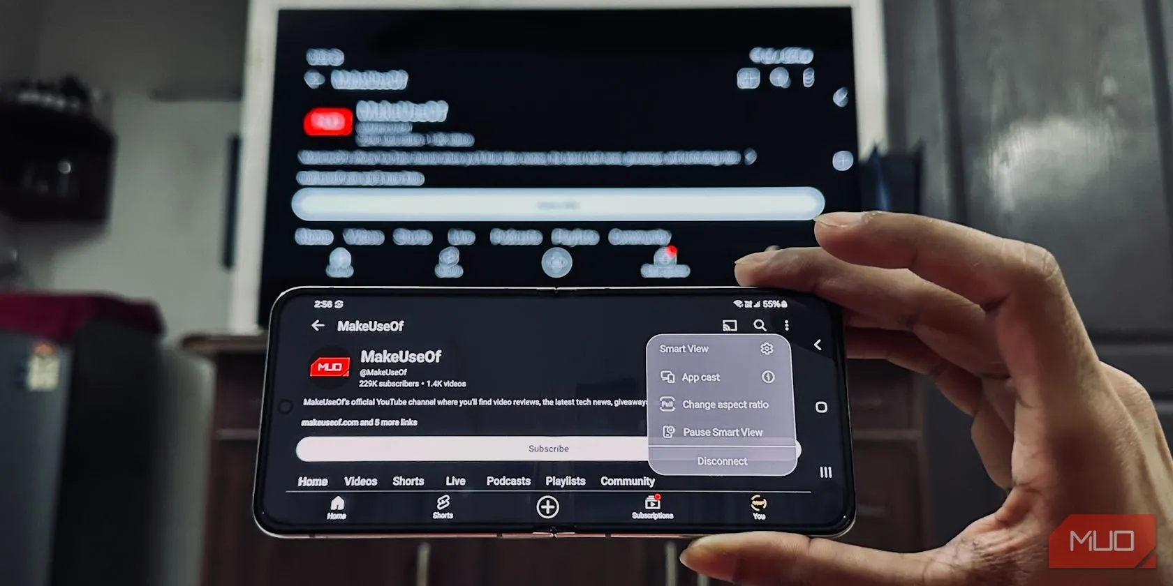 Một người đàn ông đang phản chiếu màn hình điện thoại Samsung Galaxy Z Flip 5 lên TV LG trong phòng khách.