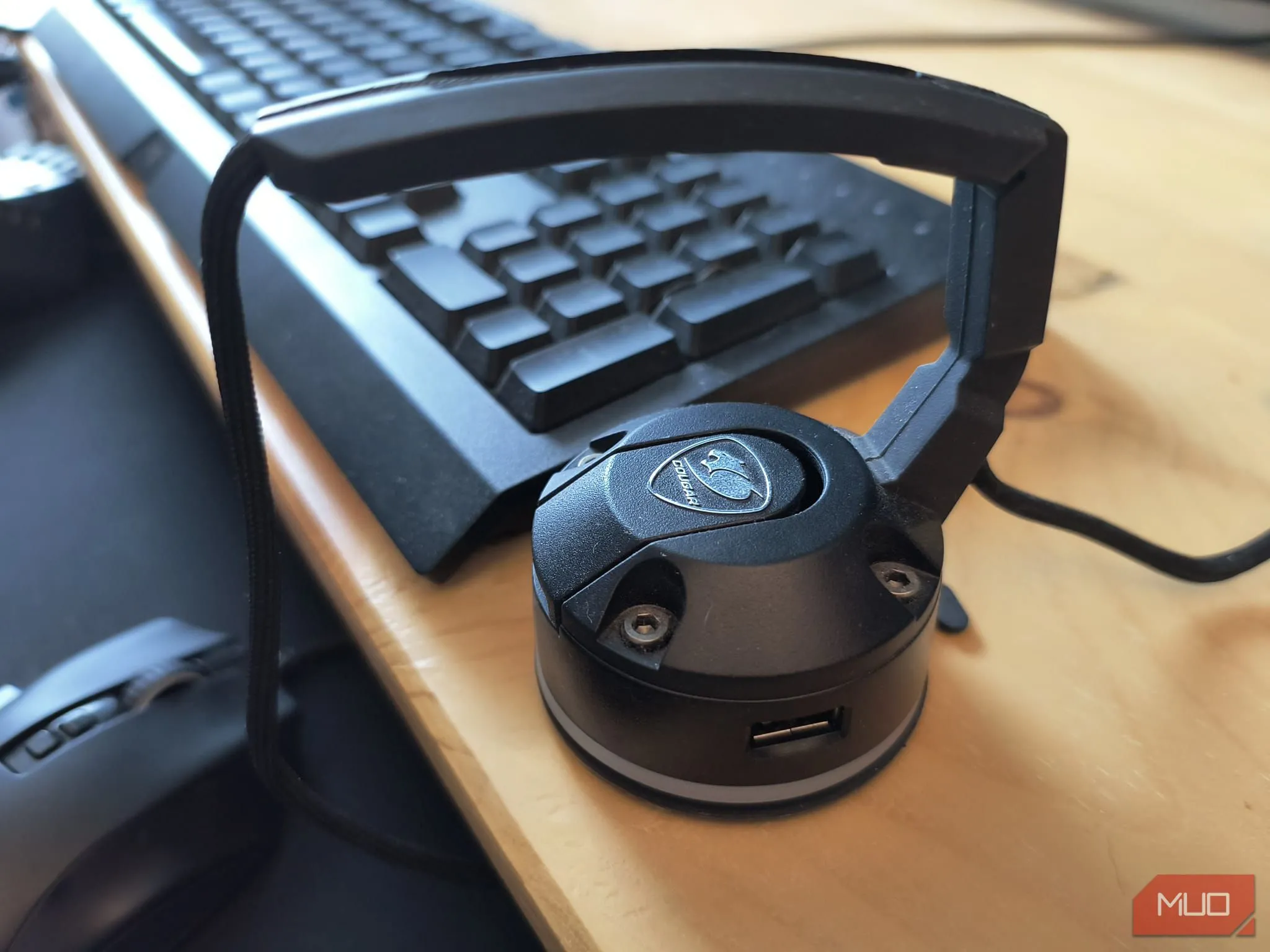 Mouse bungee màu đen đặt trên bàn gỗ, giữ dây chuột gọn gàng