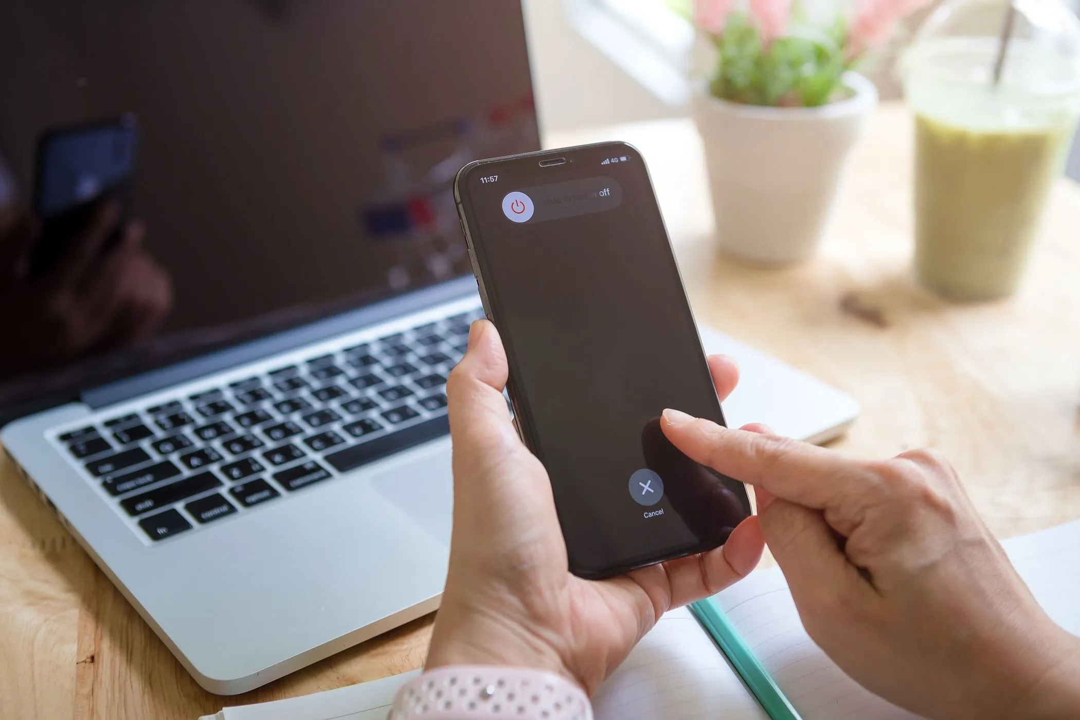 Người phụ nữ cố gắng tắt iPhone với MacBook ở hậu cảnh