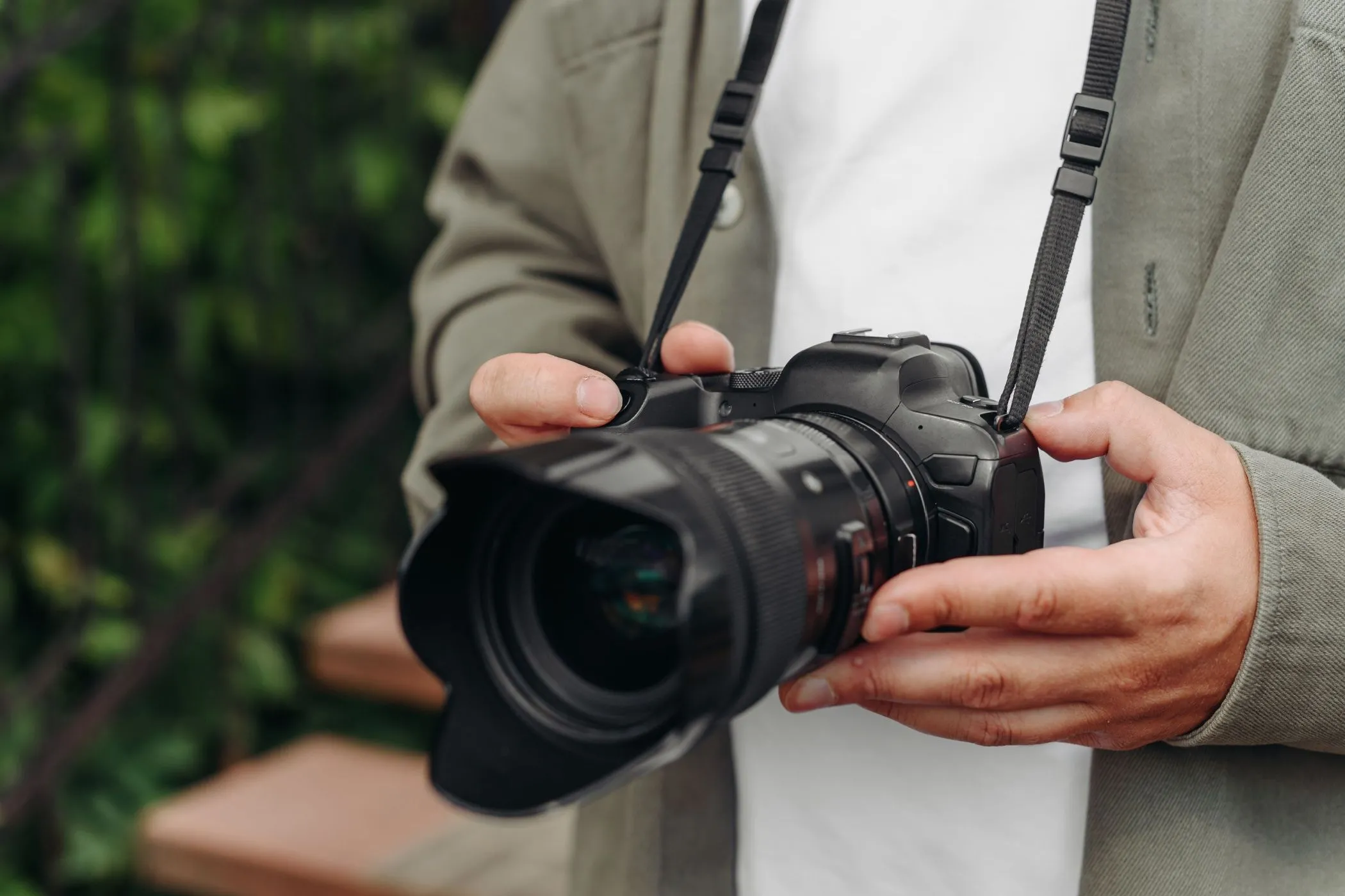 Nhiếp ảnh gia trẻ tuổi cầm máy ảnh DSLR, thể hiện sự chắc chắn và bền bỉ của thiết bị