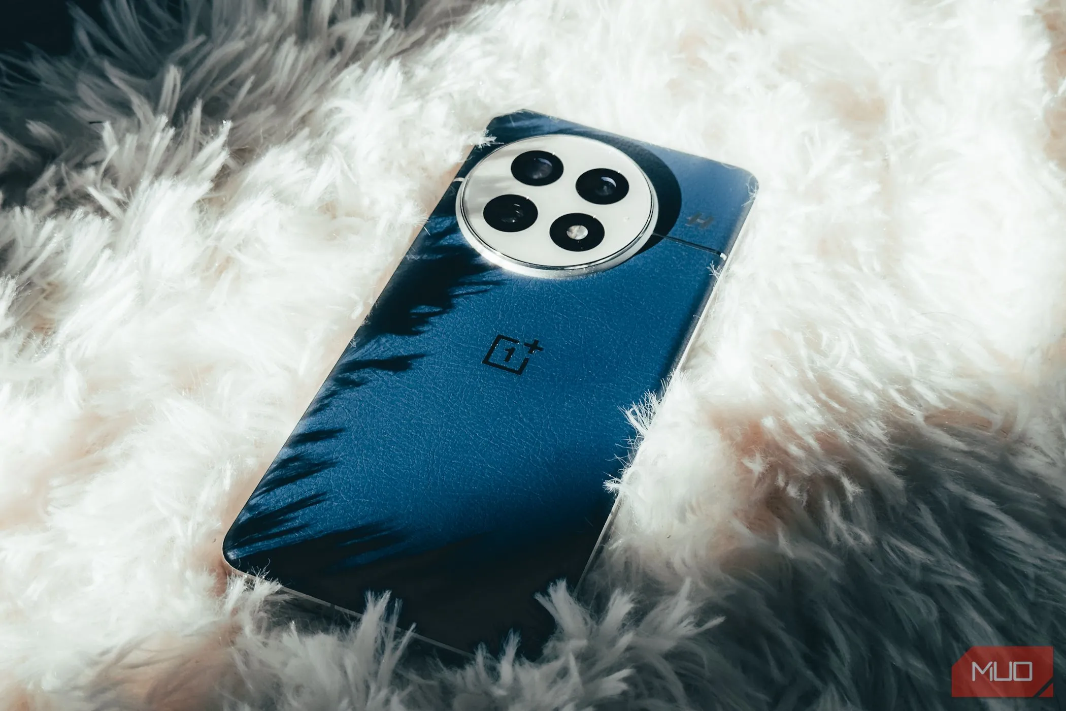 OnePlus 13 màu đen trên nền thảm lông trắng, thể hiện thiết kế tinh tế và sang trọng
