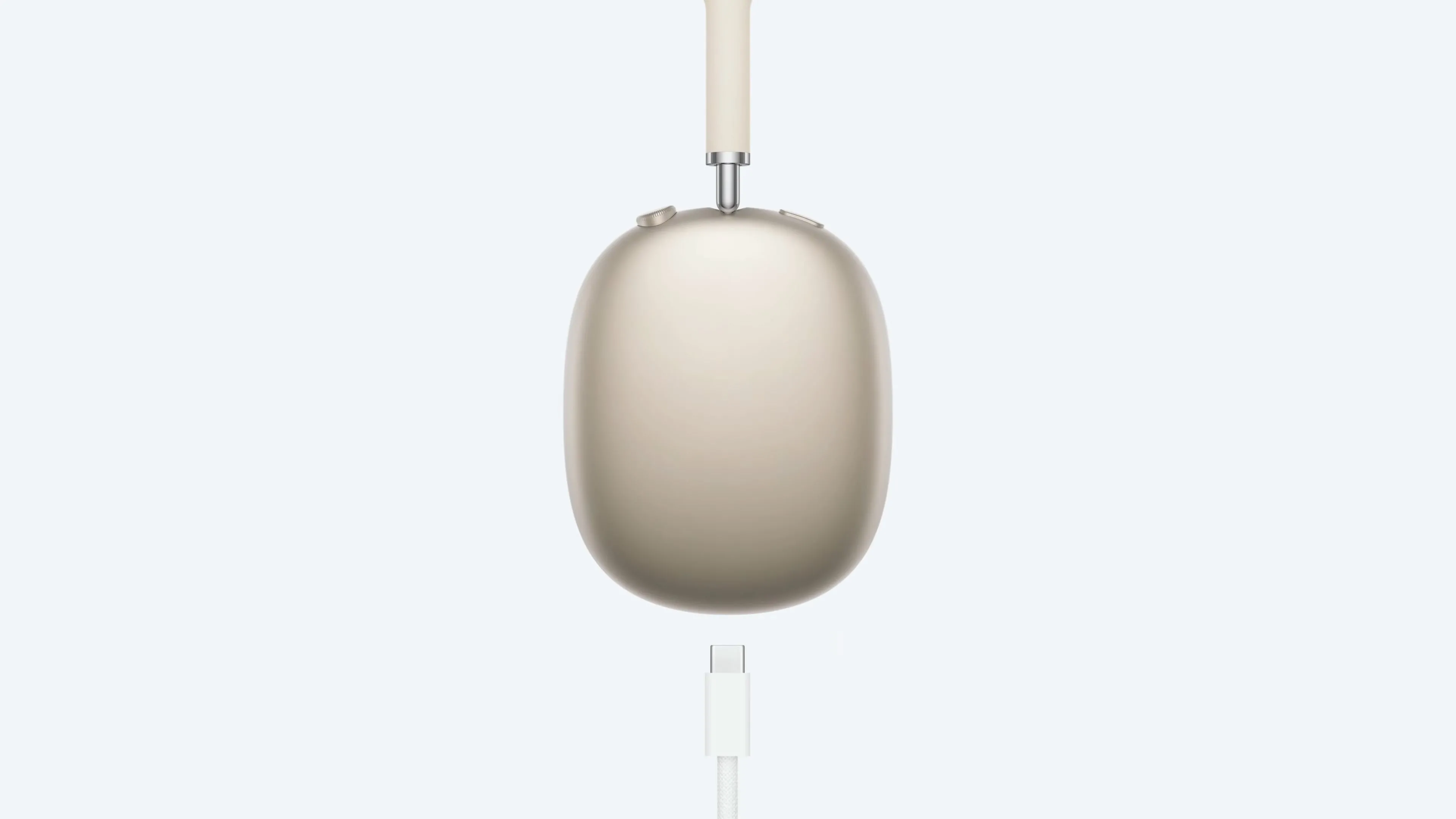 Tai nghe AirPods Max màu Starlight đang sạc bằng cáp USB-C