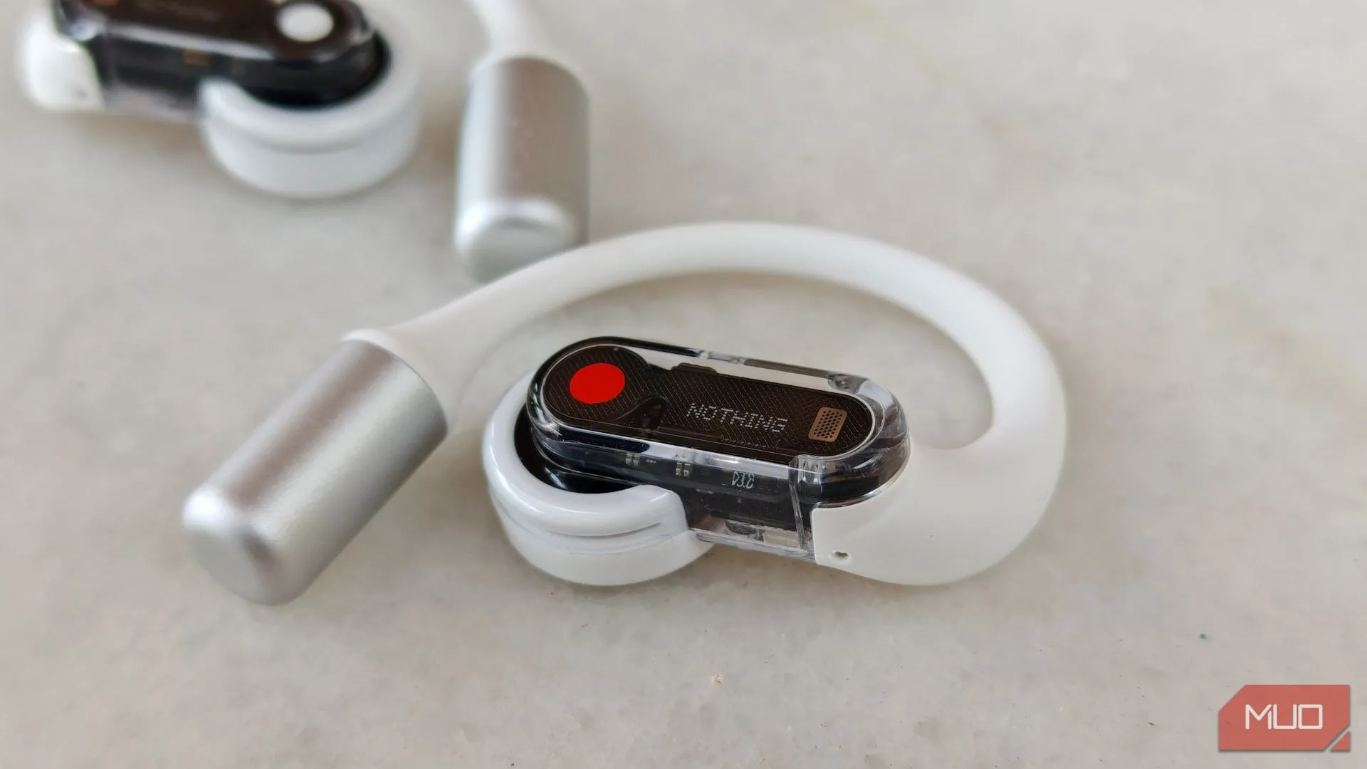 Tai nghe Nothing Ear (open) bên phải cận cảnh, với tai nghe bên trái mờ phía sau, cho thấy góc nhìn tổng thể của cặp tai nghe.