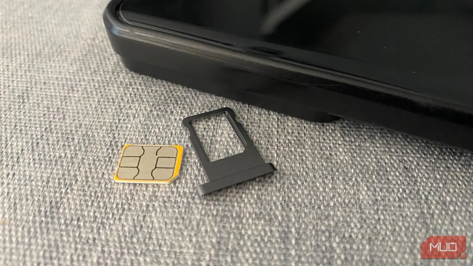Thẻ SIM vật lý và khay đựng đặt cạnh điện thoại, minh họa phương án kết nối truyền thống cho du khách.