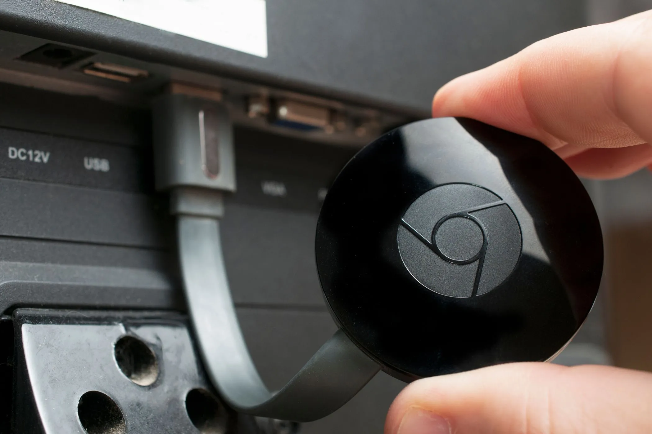 Thiết bị Chromecast được cắm vào cổng HDMI của tivi, sẵn sàng để truyền phát nội dung từ iPhone