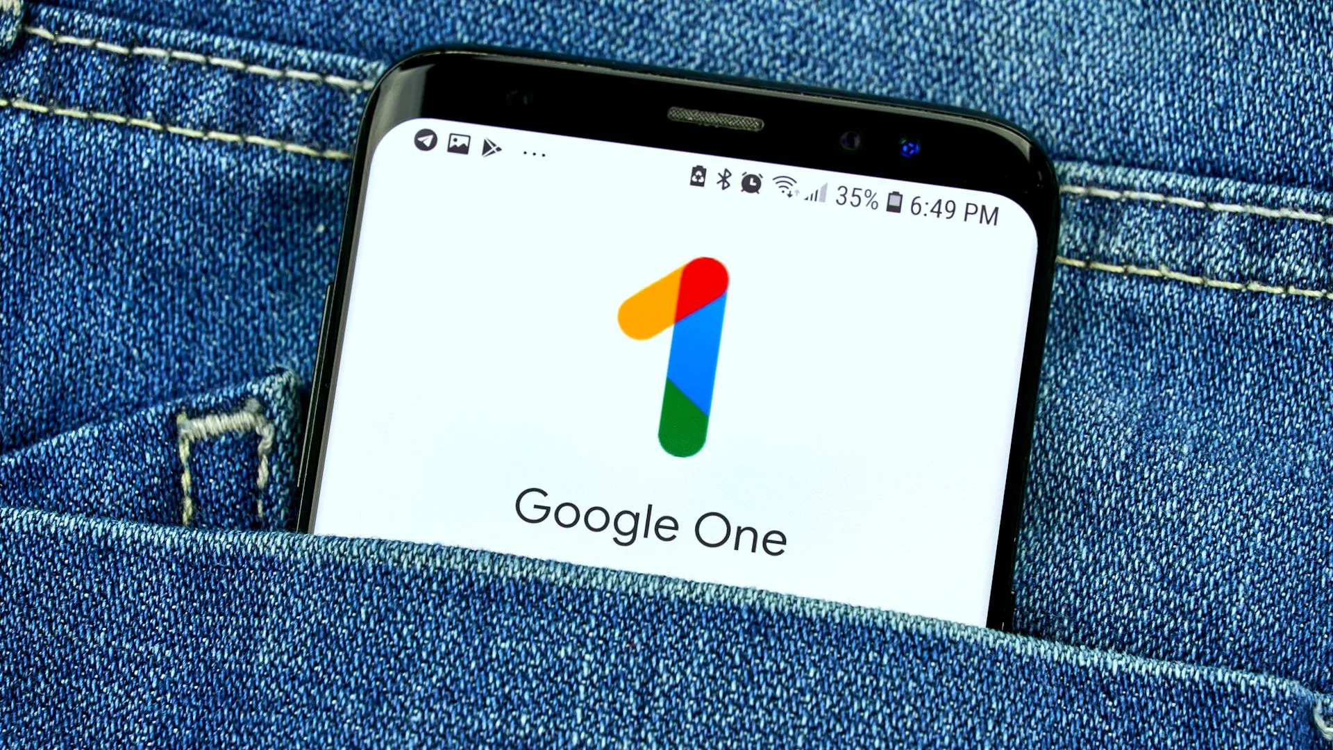 Ứng dụng Google One trên màn hình điện thoại trong túi quần jean, minh họa việc sử dụng dịch vụ đám mây trả phí như một lớp bảo vệ dự phòng theo quy tắc 3-2-1.